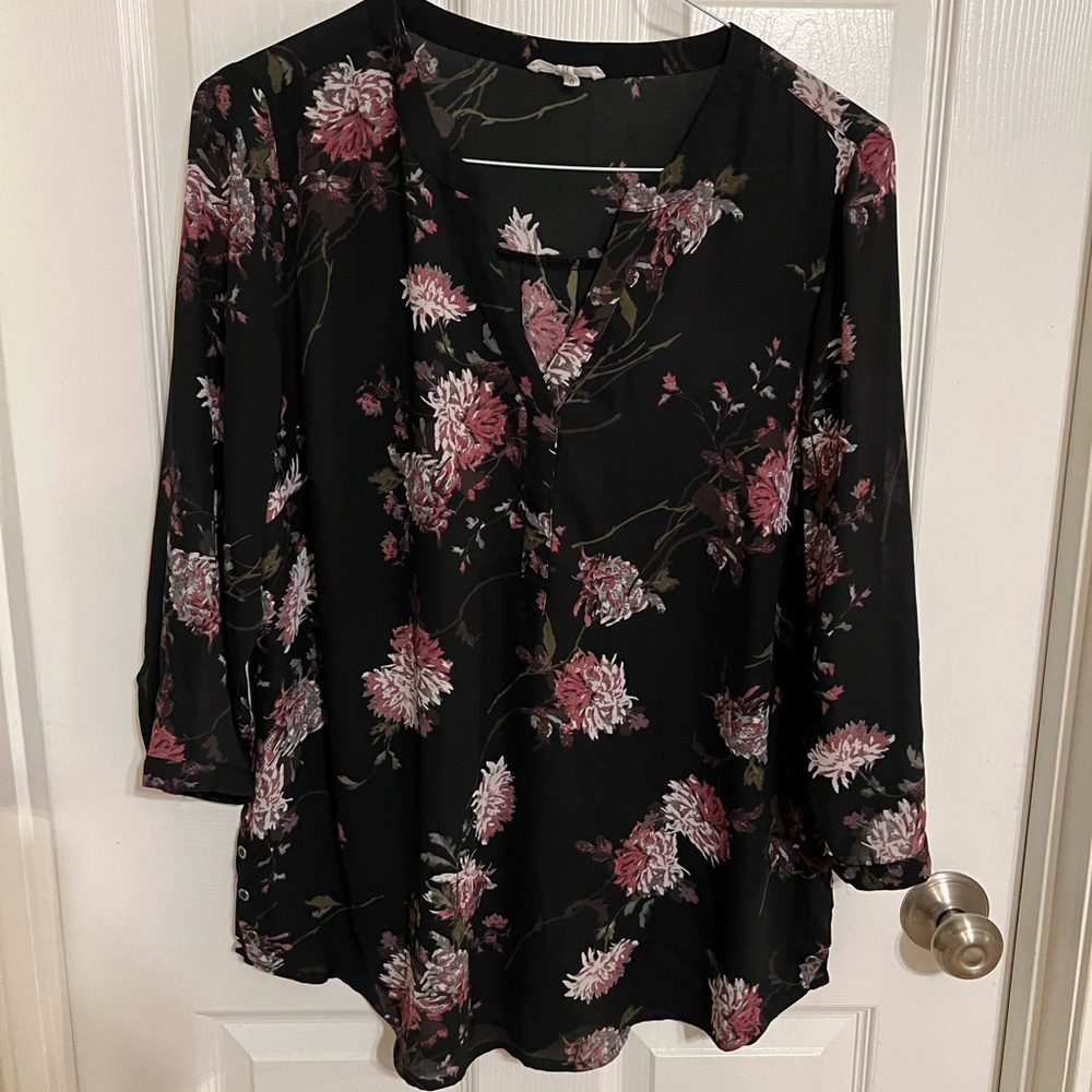 Black blouse with floral print.  Buttons on the bottom at the side seams.